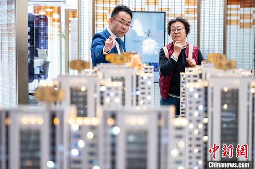 5月17日,中国人民银行官网发布《中国人民银行 国家金融监督管理总局关于调整个人住房贷款最低首付款比例政策的通知》。资料图为山西太原一售楼部置业顾问为市民推荐商品住宅。 5月17日,中国人民银行官网发布《中国人民银行 国家金融监督管理总局关于调整个人住房贷款最低首付款比例政策的通知》。资料图为山西太原一售楼部置业顾问为市民推荐商品住宅。